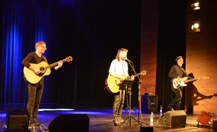 Trzech gitarzystów na scenie Jasielskiego Domu Kultury
