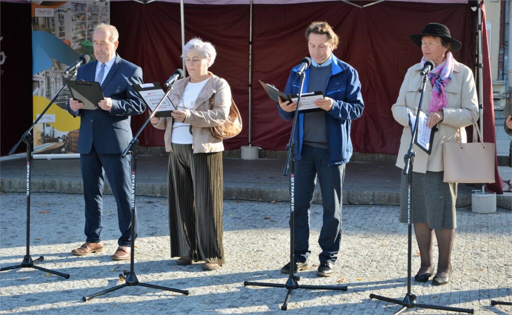 Obraz zawiera: dwie kobiety i dwóch mężczyzn stoi przed mikrofonem i recytują balladę Adama Mickiewicza w ramach Narodowego Czytania 2022.