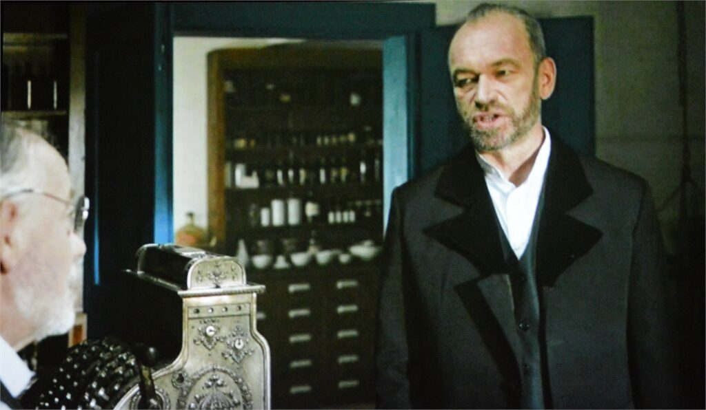 Obraz zawiera: dwóch mężczyzn rozmawia, stojąc naprzeciwko siebie. Kadr z filmu, Łukasiewicz, nafciarz romantyk.