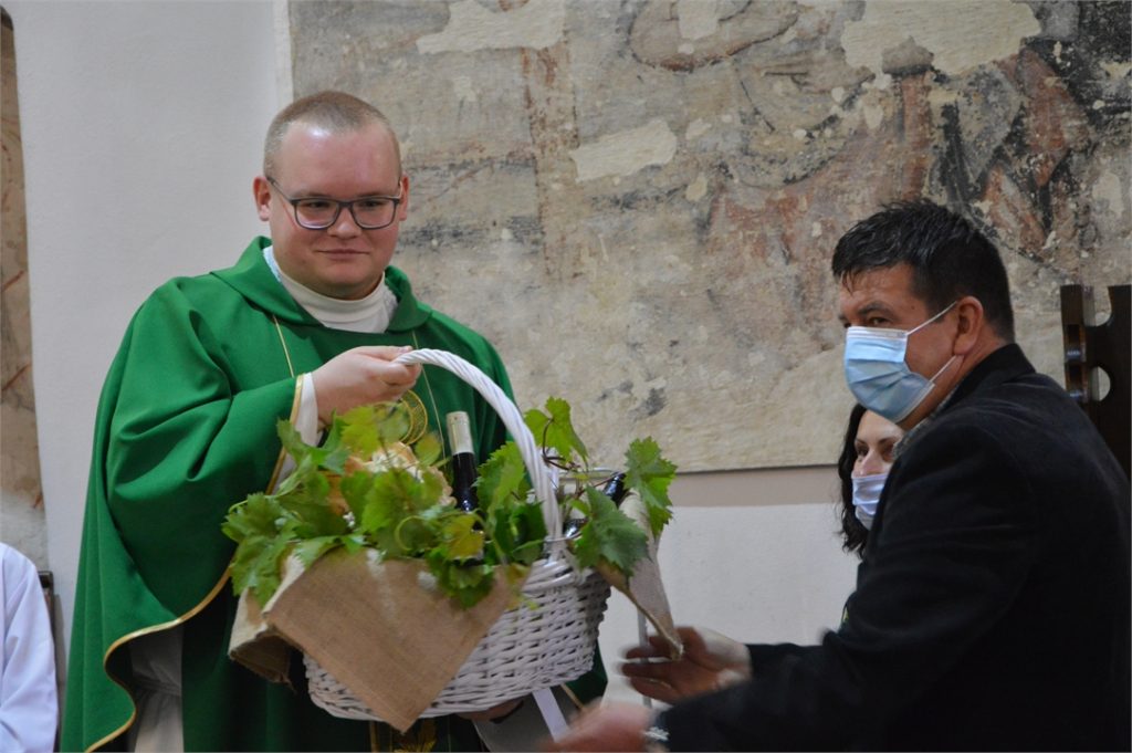 Ksiądz Marek Drupka odbiera od winiarzy dziękczynne dary za urodzajny rok