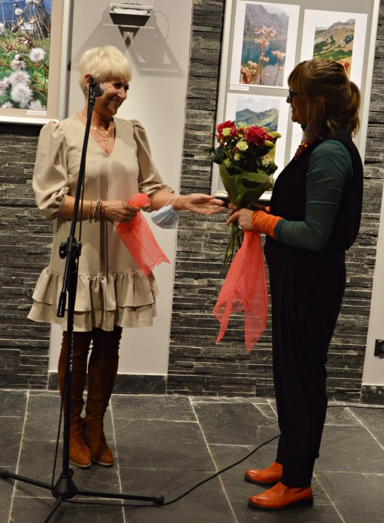 Dyrektor jasielskiego domu kultury Helena Gołębiowska wręcza kwiaty autorce wystawy