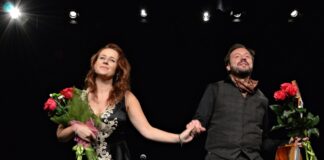 Marlena Szpak i Oscar Bellomo: koncert premierowy w Jasielskim Domu Kultury Na przyciemnionej scenie stoją kobieta (od lewej) i mężczyzna (po prawej). Kobieta ma czarną długą suknię z białym haftowanym wzorem na całej długości, w prawej ręce trzyma bukiet czerwonych róż. Ma długie rude kasztanowe, pofalowane włosy. Mężczyzna obok trzyma ją za rękę. Ubrany jest na czarno, ma zapinaną kamizelkę w kratę i brązową chustkę pod szyją. W prawej ręce trzyma gitarę i bukiet czerwonych róż. Uśmiecha się do publiczności