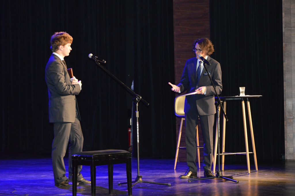 Na scenie stoją z lewej strony Piotr Jaworski pianista i student dyrygentury, a z lerwej Adam Głaczyński dziennikarz Polskiego Radia Rzeszów. Przed nimi stoją mikrofony. Rozmawiają ze sobą.