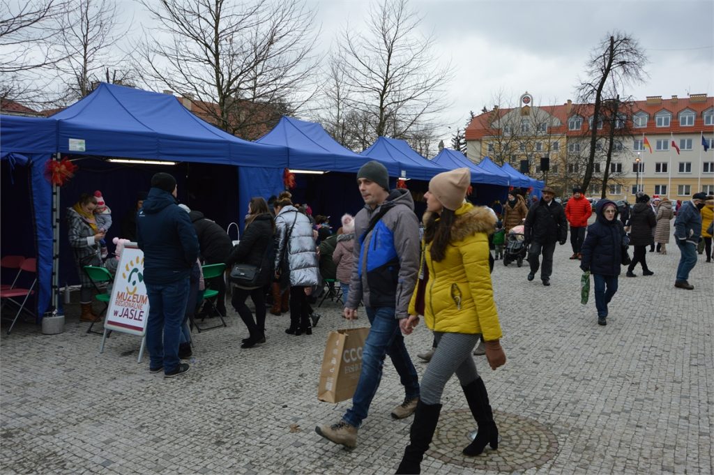 Jarmark Bożonarodzeniowy na jasielskim rynku. Klienci przed budkami i namiotami z regionalnymi wyrobami