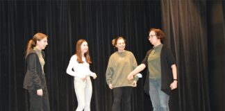 Wyrazić siebie na scenie Obraz zawiera cztery osoby. Czterty osoby stoja na scenie podczas próby w tracie warsztatów teatralnych