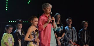 Pierwszy Supertalenciak w Jaśle Na zdjęciu grupa uczestników konkursu Talenciaki. Dzieci i młodzież stoją na scenie razem z pomysłodawczynią konkursu, która przemawia do publiczności