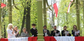 Wokalisci i soliści JDK śpiewają w jasielskiej Glorietce przybranej w barwy narodowe