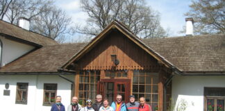 Uczestnicy wycieczki rowerowej przed dworkiem Marii Konopnickiej