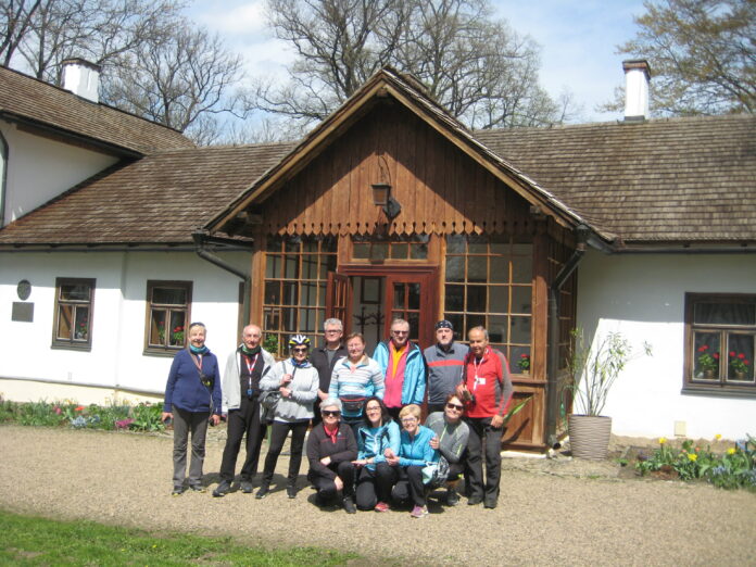 Uczestnicy wycieczki rowerowej przed dworkiem Marii Konopnickiej