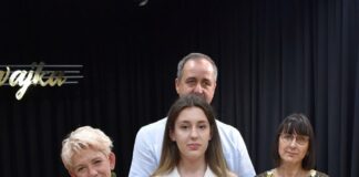 III Nagroda dla Karoliny Polak w Krasnem Obraz zawiera: cztery osoby pozyjące do zdjęcia. Trzy kobiety i mężczyzna. Na pierwszym planie Karolina Polak ze statuetką i dyplomem za zajęcia trzeciego miejsca w Wojewódzkim Konkursie Piosenki Dzięciecej i Młodzieżowej „Śpiewajka”