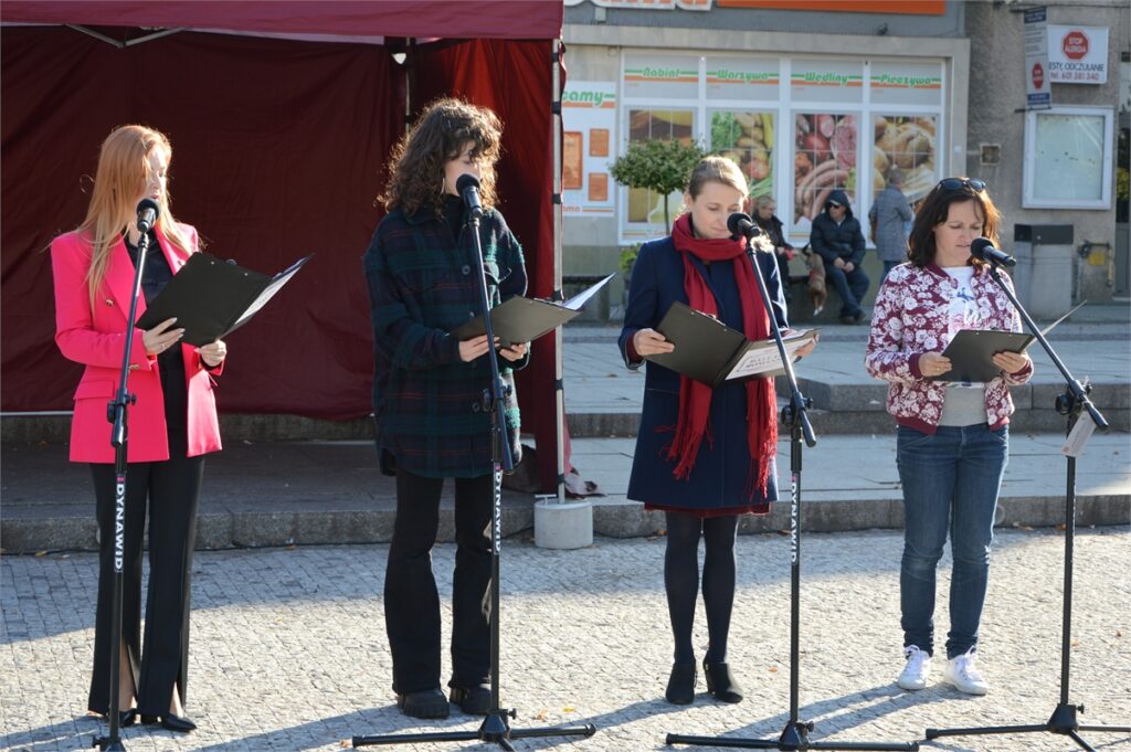 Obraz zawiera: cztery kobiety stoją przed mikrofonem i recytują balladę Adama Mickiewicza w ramach Narodowego Czytania 2022.