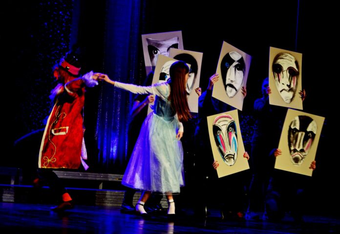 Bajkowo i z fantazją - widowisko pt. „WYczarujMY” Na granatowo oświetlonej scenie przewijają się postacie ukryte pod tekturowymi maskami. Widoczni są tylko Karolina Zabawa i Jonatan Maciejowski