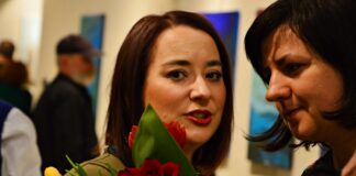 Łemkowskie Kabaty i …abstrakcja Na pierwszym planie od lewej Patrycja Dyląg, autorka wystawy, trzyma bukiet kwiatów rozmawia z uczestniczką wystawy