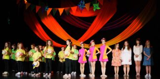 Na scenie, stojący recytatorzy, soliści i tancerze Jasielskiego Domu Kultury.