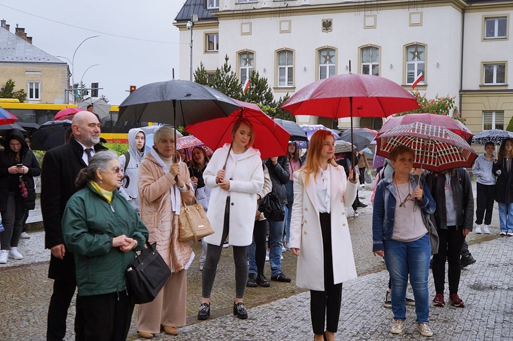 Grupa dorosłych osób, stojących pod parasolami. Wszyscy z zaciekawieniem obserwują radosny taniec dzieci. Wśród nich Pani Dyrektor Jasielskiego Domu Kultury – Helena Gołębiowska. 