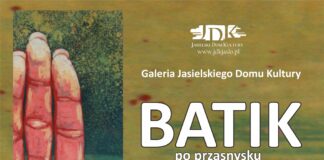 baner na oliwkowym tle znajdują się białe napisy informujące o batiku. pod nimi logotypy pracowni batiku mamut i miejskiego domu kultury z przasnysza, nieco niżej logotyp tojoty. Po lewej stronie baneru, w pionie czerwona dłoń