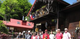 Grupa osób przed Chatą Górską na Cyrli. Wszyscy pozują do zdjęcia.