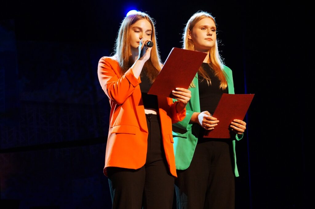 Na scenie dwie młode dziewczyny zapowiadające występy artystyczne. 