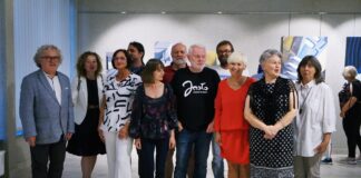 Grupa osób wraz z artystami pozuje do zdjęcia.