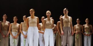 Grupa dziewcząt stoi na scenie.