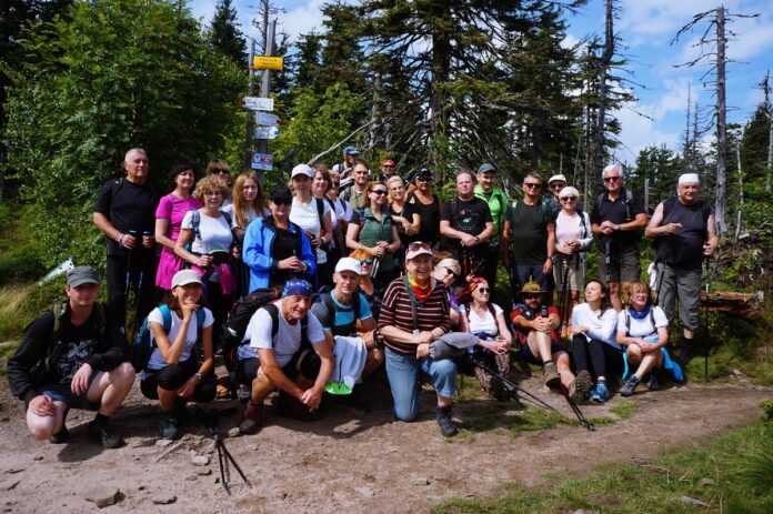 Radośni turyści pozują do zdjęcia na szczycie – Polica.