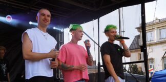 Na scenie stoi trzech młodych mężczyzn (Trzech Króli). Chłopak w czarnej koszulce przemawia do mikrofonu.