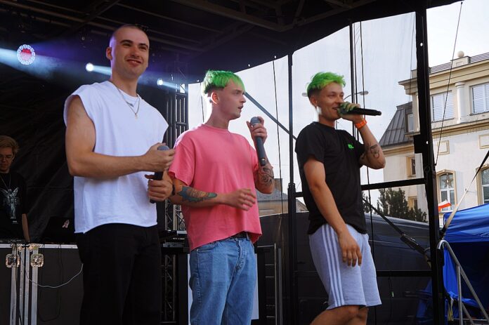 Na scenie stoi trzech młodych mężczyzn (Trzech Króli). Chłopak w czarnej koszulce przemawia do mikrofonu.