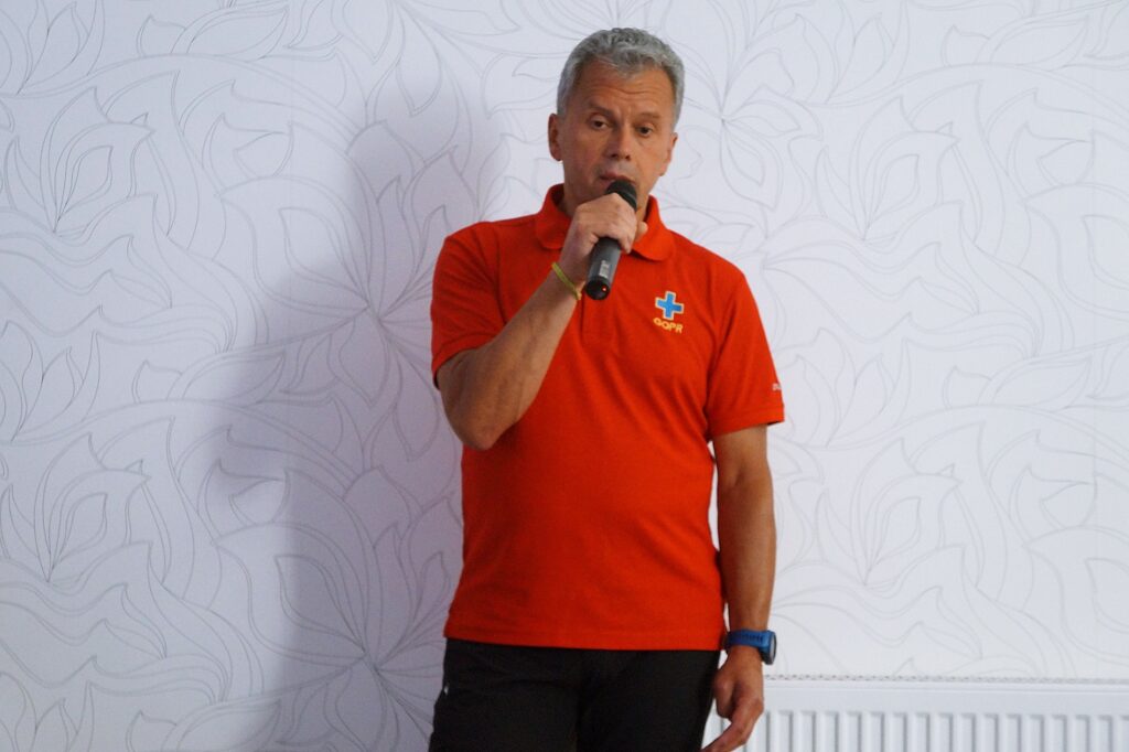 Pan Andrzej Piękoś z  Grupy Krynickiej GOPR przemawia do mikrofonu. 
