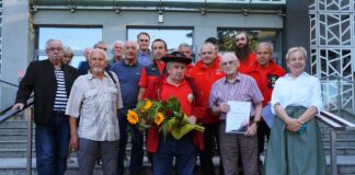 Z miłości do gór, czyli święto przewodników i ratowników górskich Przewodnicy, ratownicy górscy i sympatycy Klubu Ludzi z Pasją, radośnie pozują do wspólnego zdjęcia.