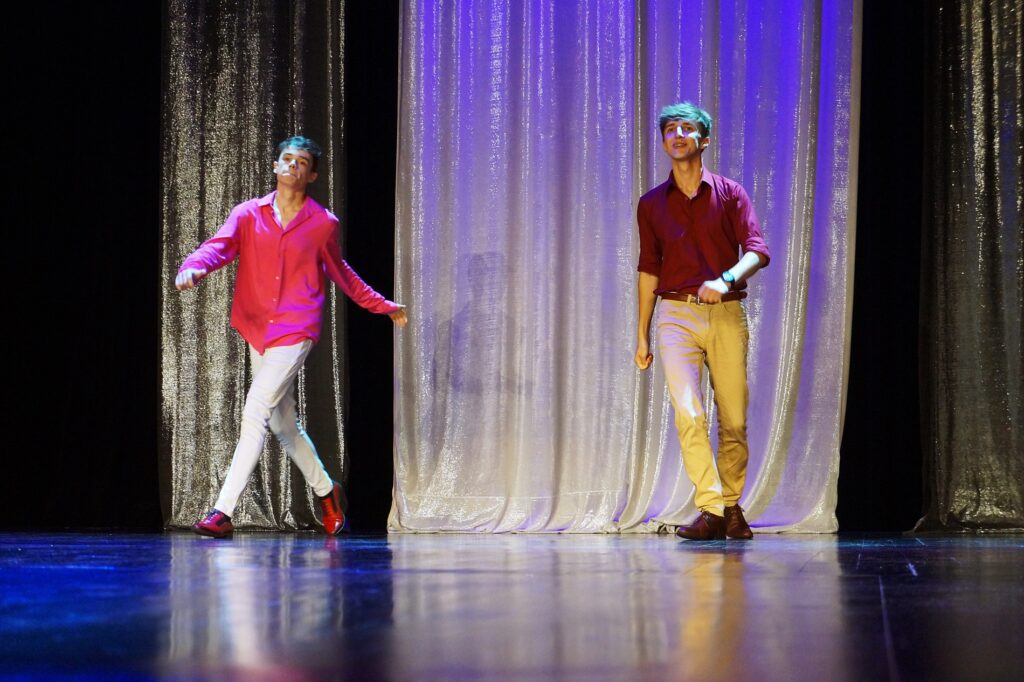 Dwaj młodzi mężczyźni tańczą na scenie. 