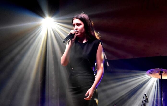 1698399865084 Na scenie stoi Karolina Polak i śpiewa piosenkę.