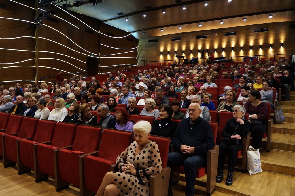 Publiczność w sali widowiskowej Jasielskiego Domu Kultury w oczekiwaniu na spektakl.