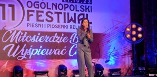 Główne Nagrody dla wokalistów JDK w Tarnowie Obraz zawiera: Młoda dziewczyna w spodniach i marynarce stoi na scenie i śpiewa do mikrofonu trzymanego w prawej ręce podczas 11 Ogólnopolskiego Festiwalu Pieśni i Piosenki Religijnej.
