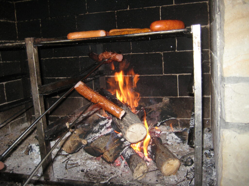 Pieczenie kiełbasek przy kominku grillowym w Dębowcu.