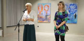 Dwie kobiety stoją obok siebie: Helena Gołębiowska, zastępca dyrektora Jasielskiego Domu Kultury i Zuzanna Kłapkowska. Wicedyrektor przemawia do mikrofonu i wita wszystkich przybyłych gości.