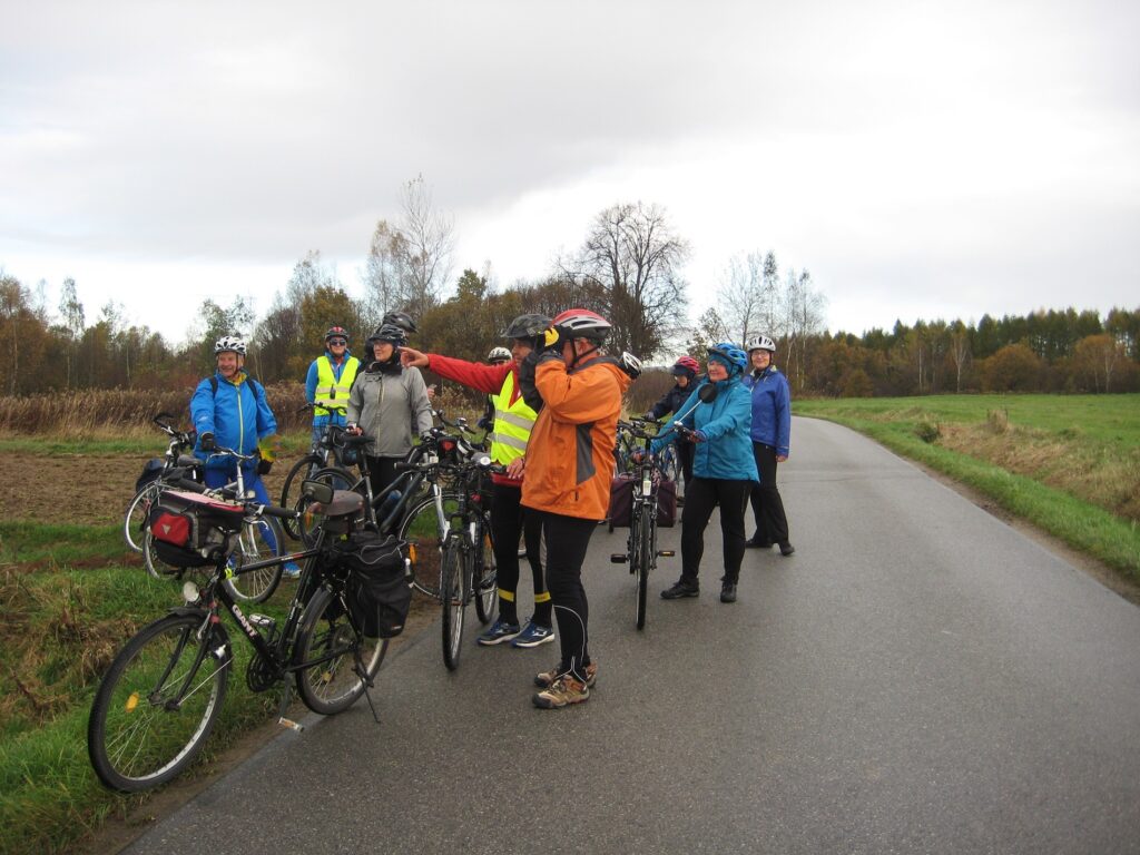 Grupa rowerzystów na rowerowym szlaku zwiedzania.