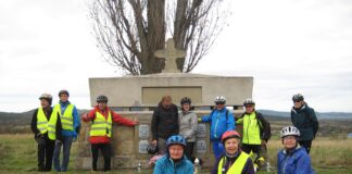 Uczestnicy wycieczki rowerowej przy pomniku nagrobnym cmentarza numer 10 w Woli Cieklińskiej.