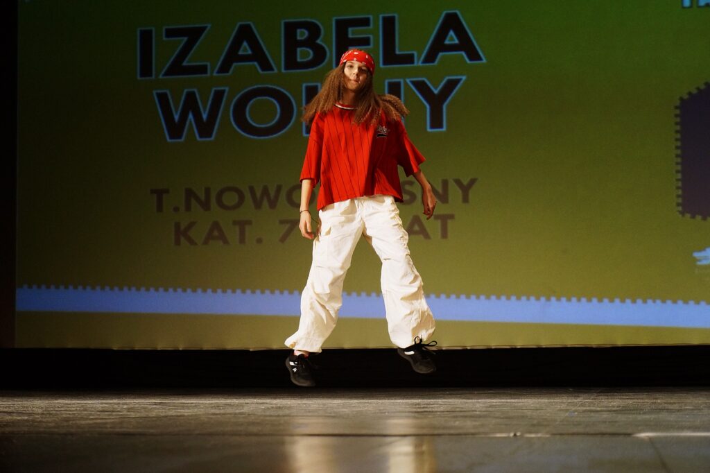 Młoda dziewczyna wykonuje swój układ choreograficzny na scenie Jasielskiego Domu Kultury.