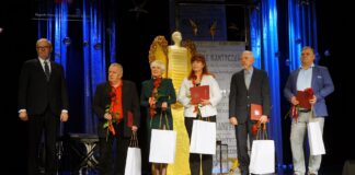 Na scenie stoją nagrodzeni działacze kulturalni. Towarzyszy im Ryszard Pabian, burmistrz Jasła.