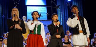 Koncert laureatów konkursu kolęd i pastorałek Czterech laureatów na scenie: dwie młode dziewczyny i dwóch chłopaków. Wszyscy śpiewają wspólnie kolędę.