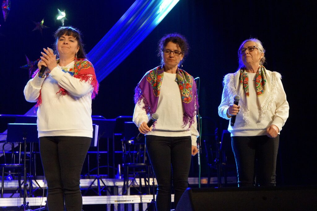 Trzy kobiety występują na scenie.