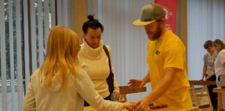 Trzy osoby: mężczyzna, kobieta i dziewczynka grają w jedną z drewnianych gier.