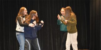 Level Up w Jasielskim Domu Kultury Obraz zawiera: Cztery młode dziewczyny na scenie teatralnej prezentują przygotowaną podczas warsztatów scenkę rodzajową.
