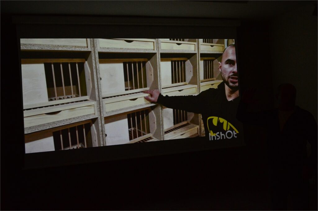 Obraz zawiera: Film wyświetlany przez gościa klubu o specjalnych domkach dla gołębi pocztowych.