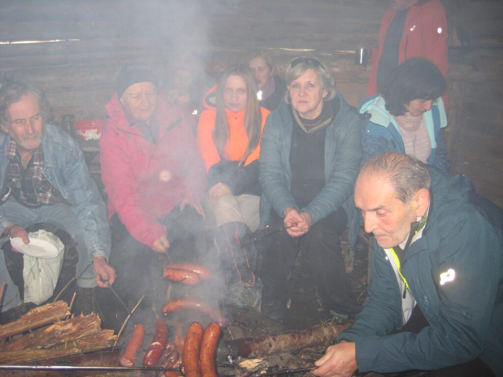 Pieczenie kiełbasek w altance grillowej.