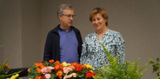 Państwo Dąbrowscy wśród kwiatów pozują do wspólnego zdjęcia.