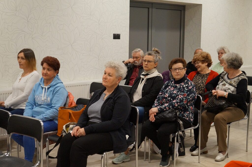 Uczestnicy spotkania z zaciekawieniem słuchają prelekcji na temat roślin doniczkowych.