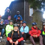 grupa rowerzystów przy zabytkowym kościele