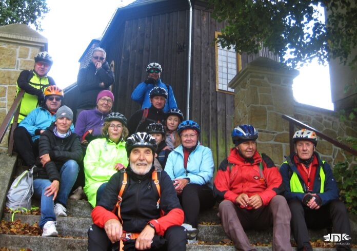 grupa rowerzystów przy zabytkowym kościele