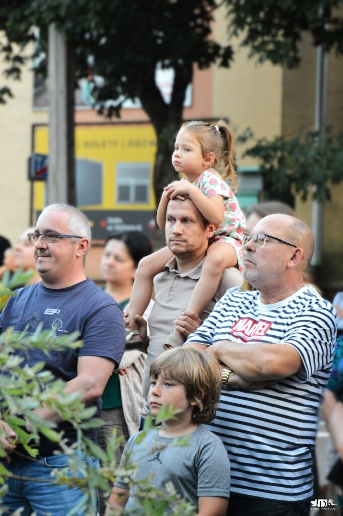 uczestnicy koncertu wraz z dziewczynką siedzącą "na barana"